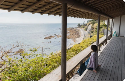 海を望む縁側でくつろぐ女性