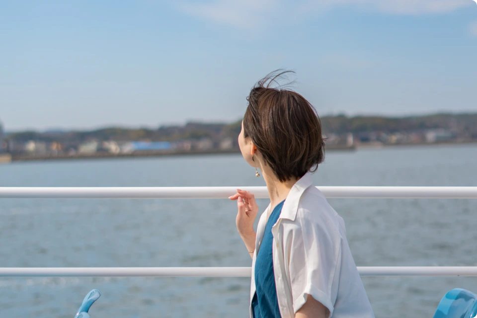 高速船のデッキから海を眺める女性