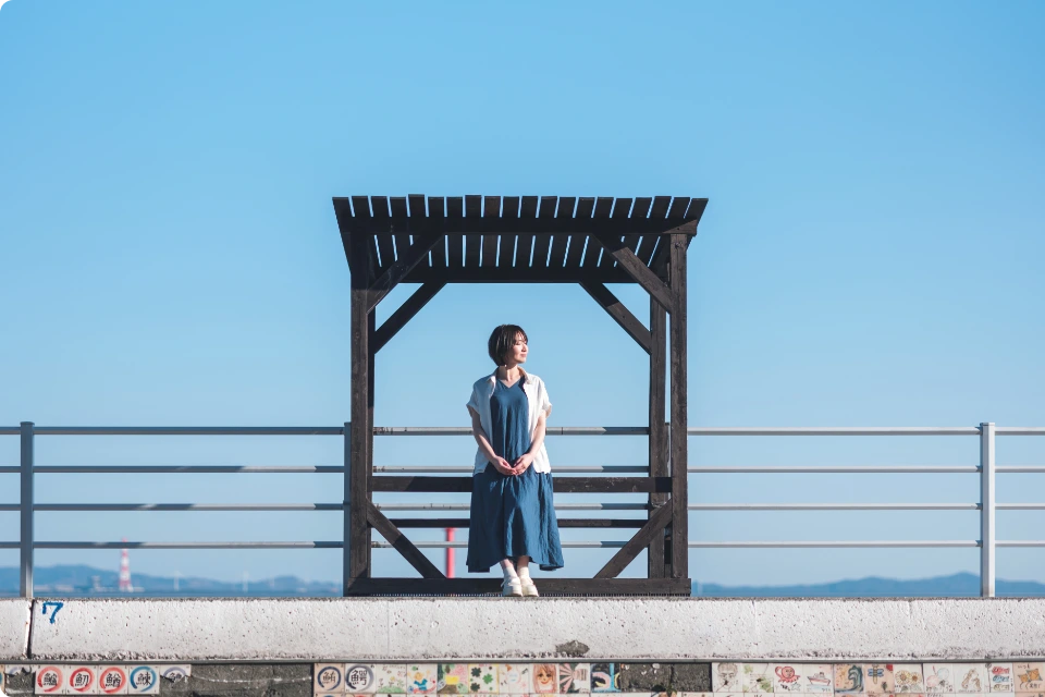 海を望むフォトスポットに立つ女性