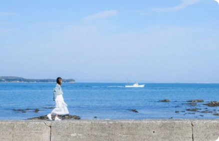 海沿いを歩く女性