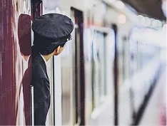 列車の扉から顔を出して安全確認をする駅員